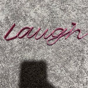 Metal sign says laugh